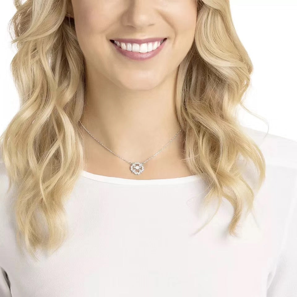 Clover dancing pendant jewelry shown on a model with a smiling expression and wavy hair