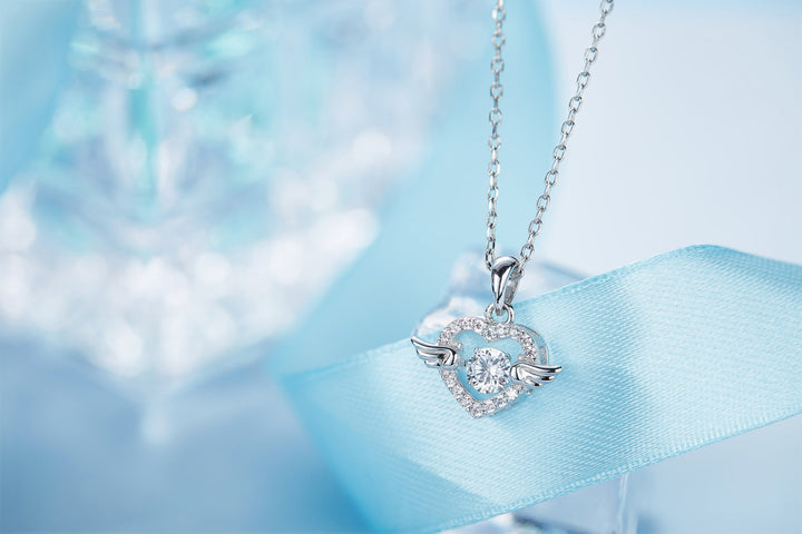 Sterling silver angel wing necklace with heart pendant and sparkling accents on a delicate chain