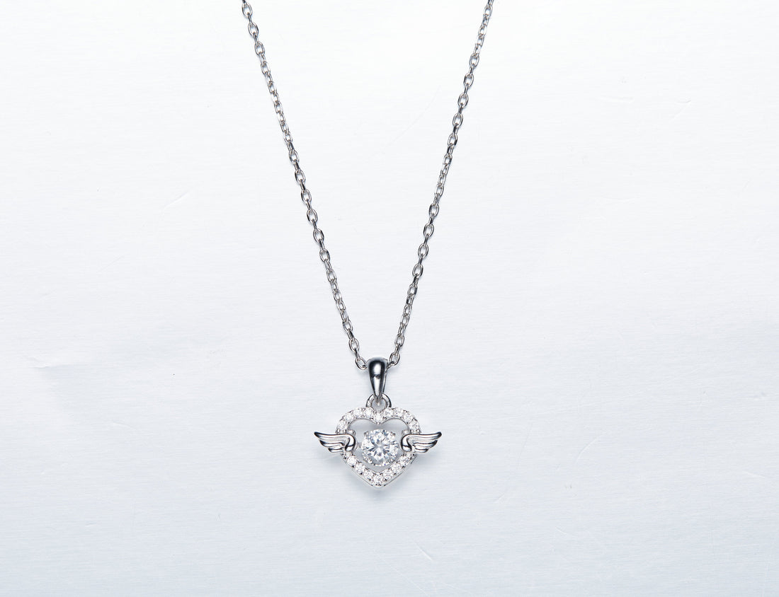 Sterling silver angel wing necklace featuring a heart pendant adorned with sparkling details